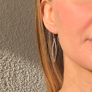 silver hammered leaf shaped hoops on ear wires on woman's ear
